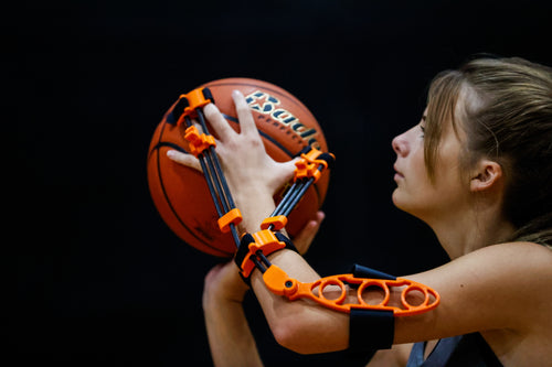 Young female player preparing to shoot indoors with proper form using Perfec'Shot, model A-21